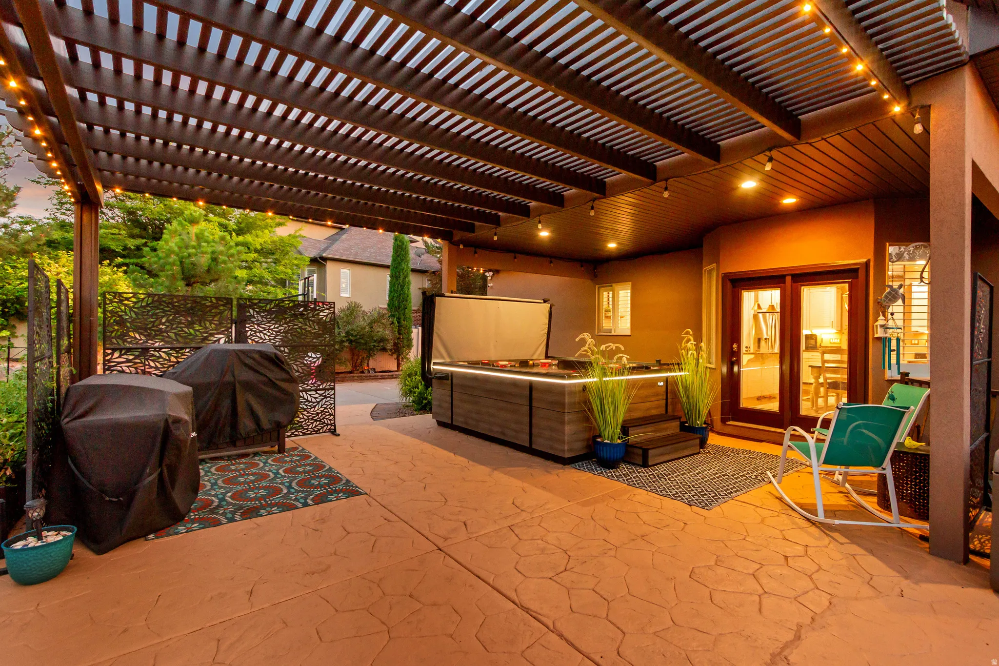 Covered patio featuring a wood slatted pergola, recessed lighting, and stamped concrete flooring