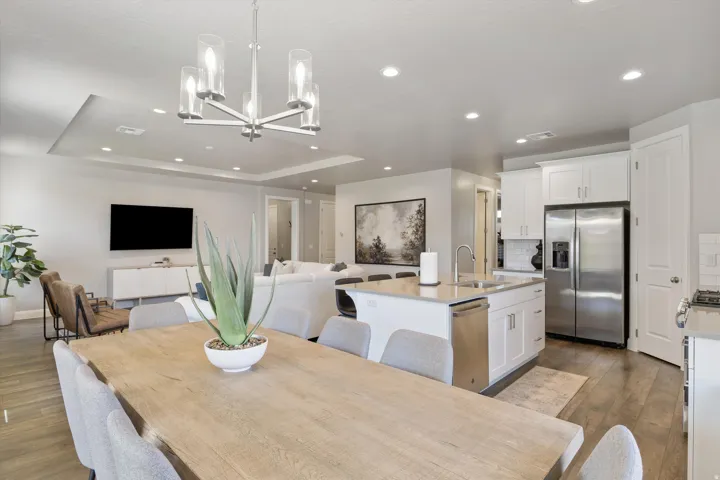 Open-concept living space featuring wood-finish flooring, recessed lighting, and a tray ceiling