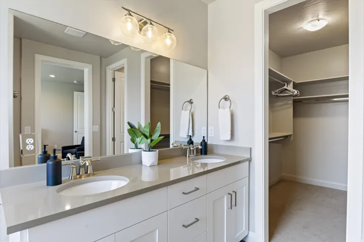 Dual vanity with undermount sinks, light-toned countertop, and white cabinetry