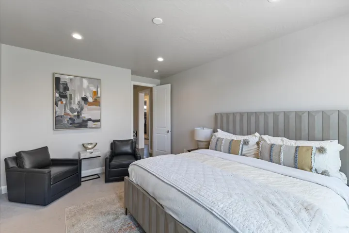 Recessed ceiling lighting, light neutral wall paint, and a built-in headboard