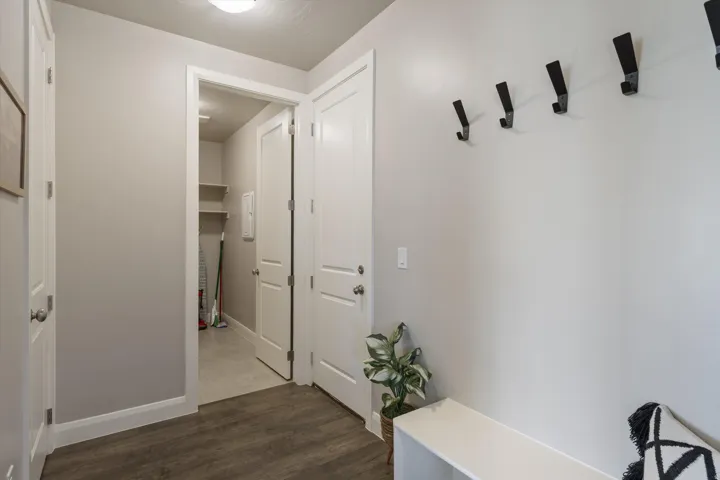 Entryway featuring wood-finish flooring, white trim, and a built-in bench