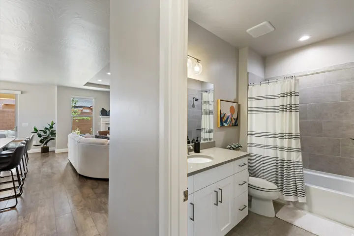 White vanity with a light countertop, integrated sink, and dark hardware