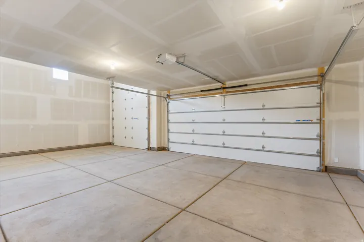 Spacious garage featuring concrete flooring, multiple garage doors, and an automatic garage door opener