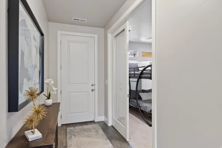 Entryway featuring wood-finish flooring, a paneled door, and a partially open doorway revealing a separate space