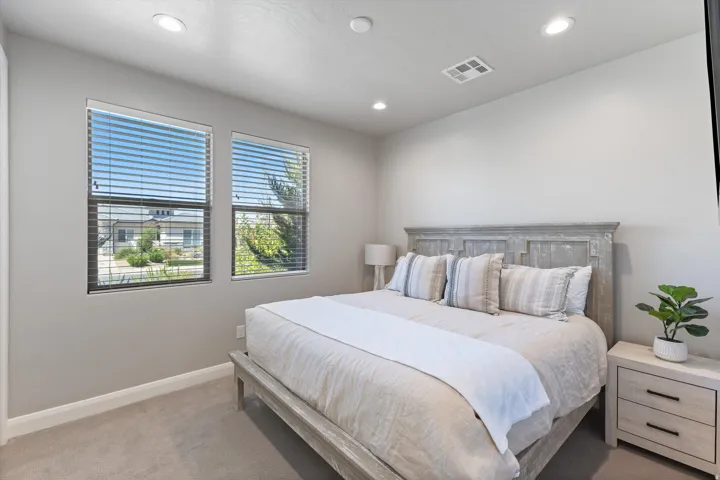 Recessed lighting, light-toned carpeting, two windows with blinds, and neutral wall tones