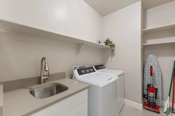 Laundry area featuring a built-in utility sink, countertop space, and open shelving