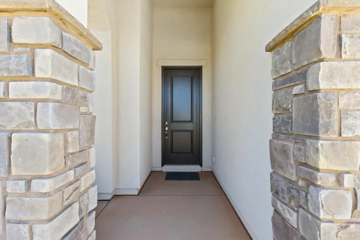 Stone veneer columns framing the entryway with a solid panel door