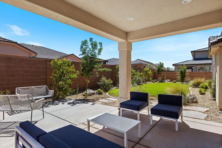 Covered patio featuring recessed lighting, concrete flooring, and a manicured lawn area