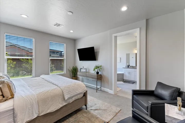 Recessed lighting, light gray walls, dual windows with horizontal blinds, and carpeting