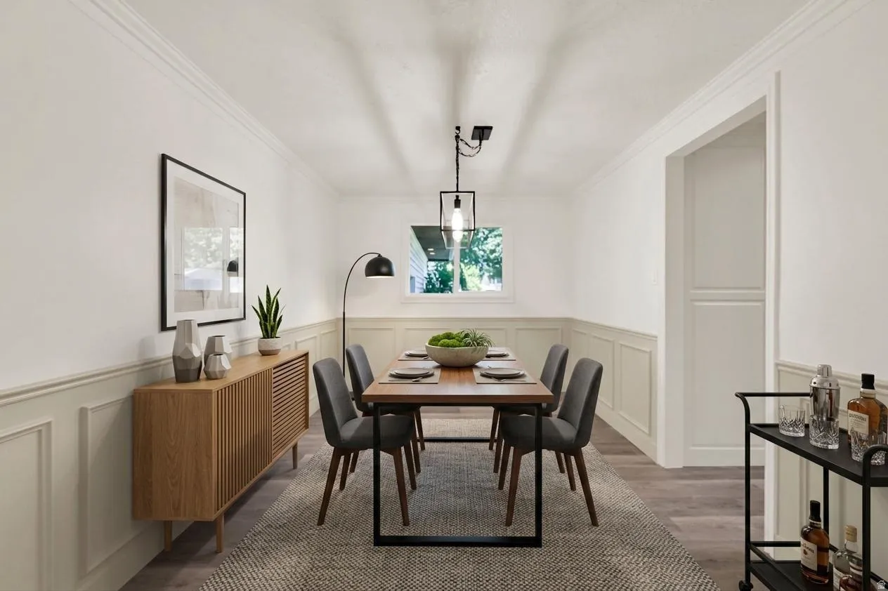 Room featuring crown molding, wainscoting, and wood-finish flooring