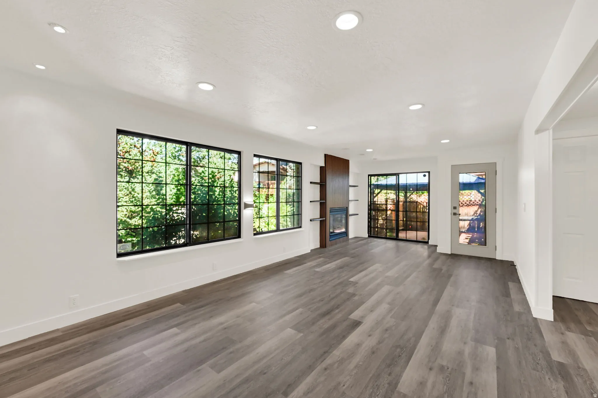 Spacious interior with wood-finish flooring, recessed lighting, and large windows