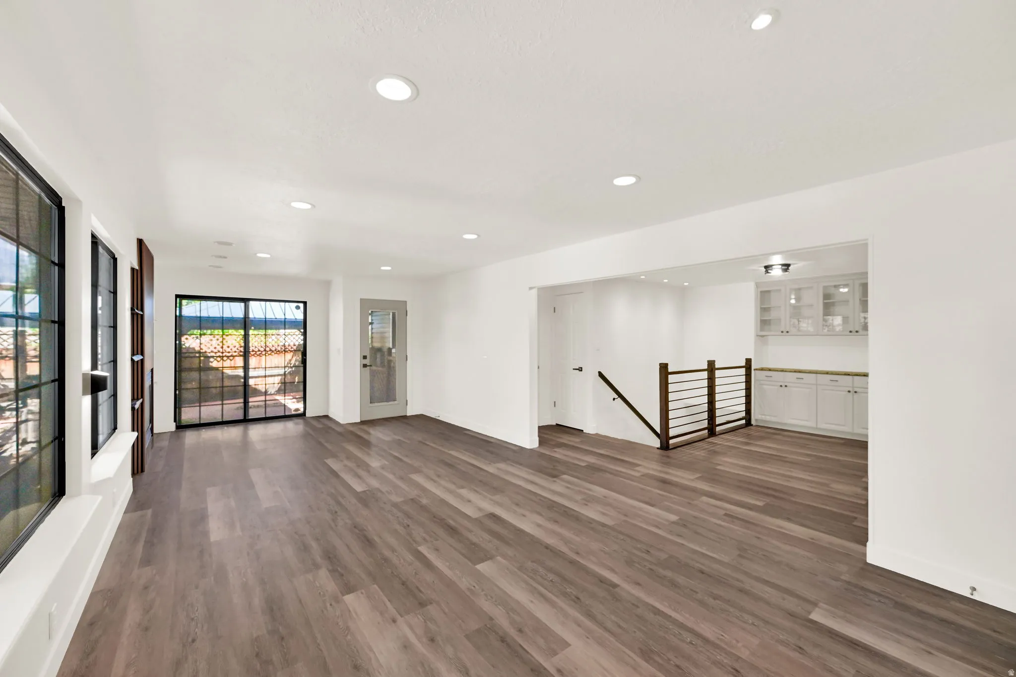 Wood-finish flooring throughout, recessed lighting, and white walls