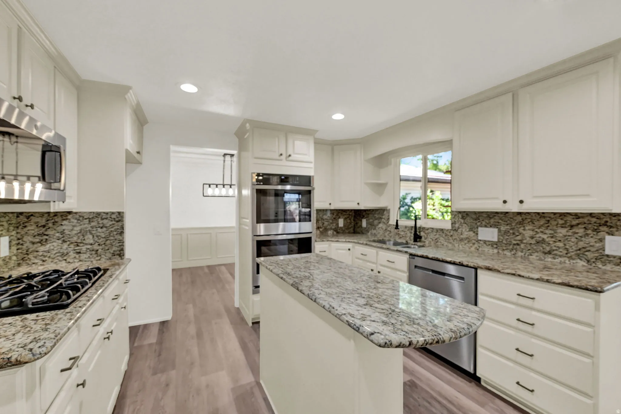 Kitchen featuring an island, recessed lighting, and wood-finish flooring