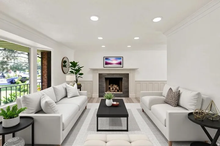 Recessed lighting illuminating the living space, featuring a fireplace with a stone surround and a white mantel
