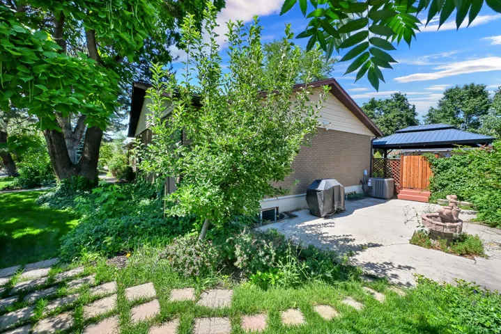 Concrete patio with privacy fencing and a gazebo featuring a dark metal roof