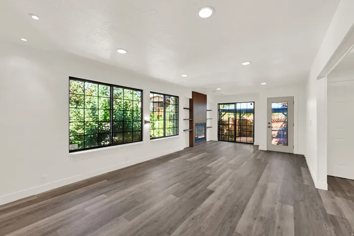 Spacious interior with wood-finish flooring, recessed lighting, and large windows