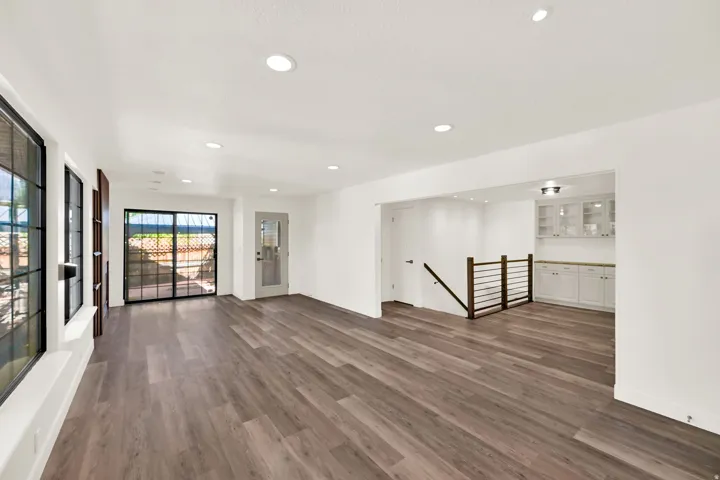 Wood-finish flooring throughout, recessed lighting, and white walls