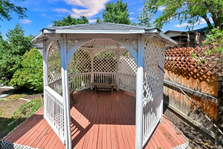 Hexagonal gazebo featuring a lattice perimeter and a built-in bench