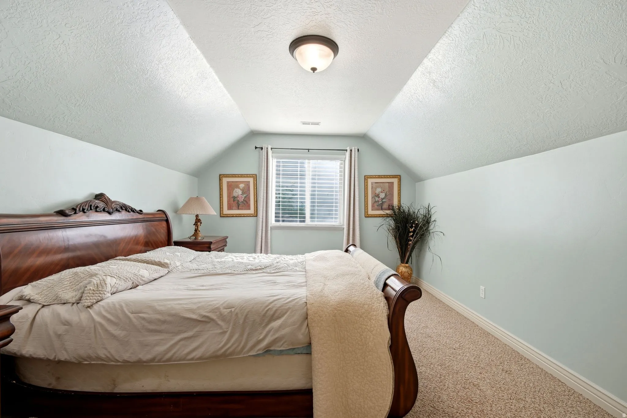 Carpeted flooring, vaulted ceiling, recessed window, and flush mount lighting