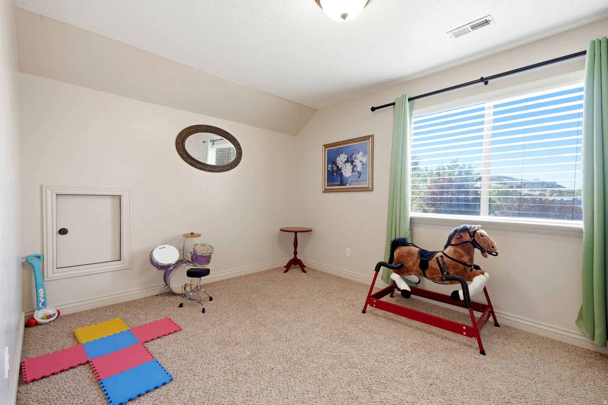 Carpeted room featuring a large window, white blinds, and an access panel