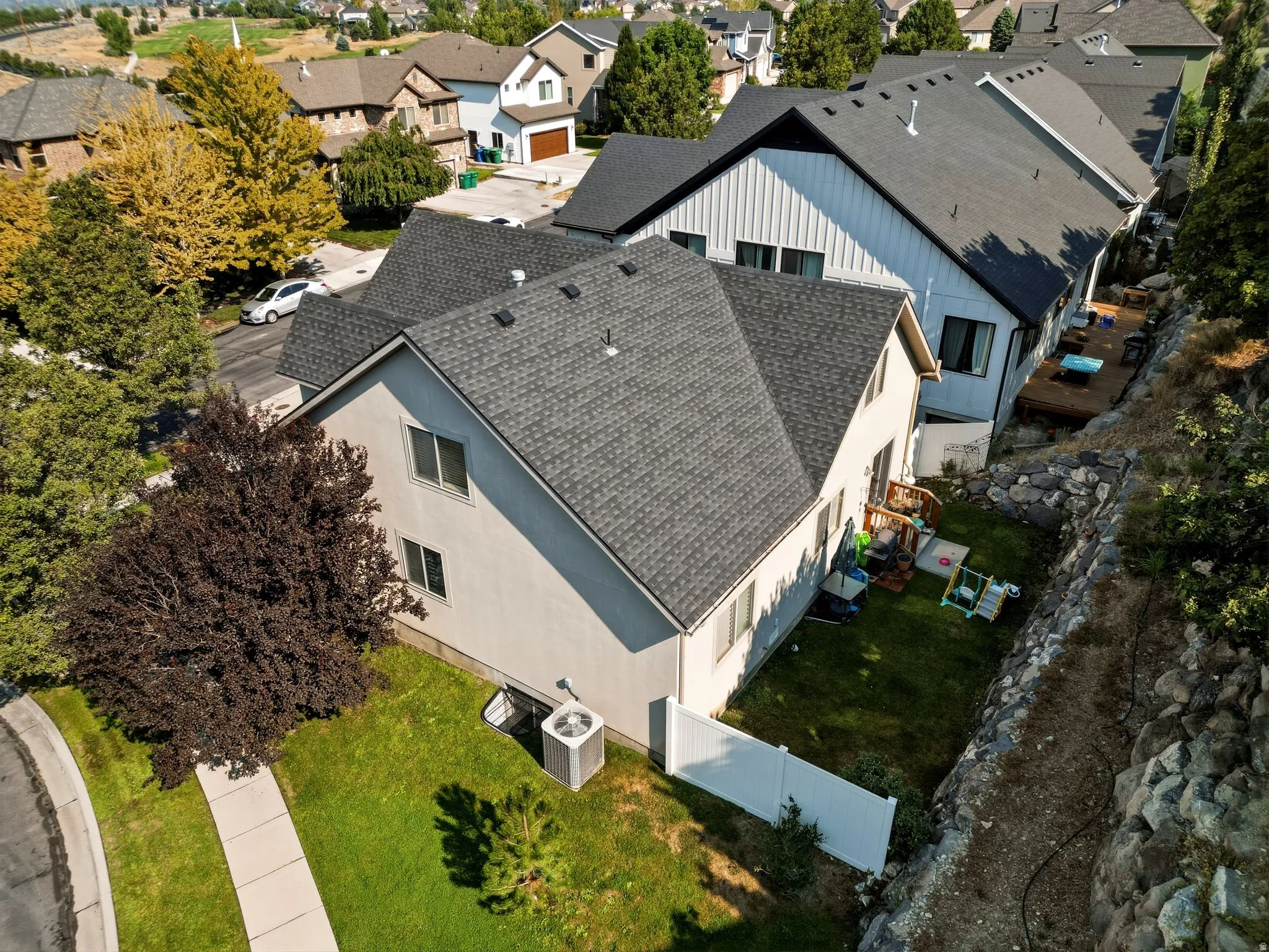 Two-story property with a gray shingle roof and stucco siding