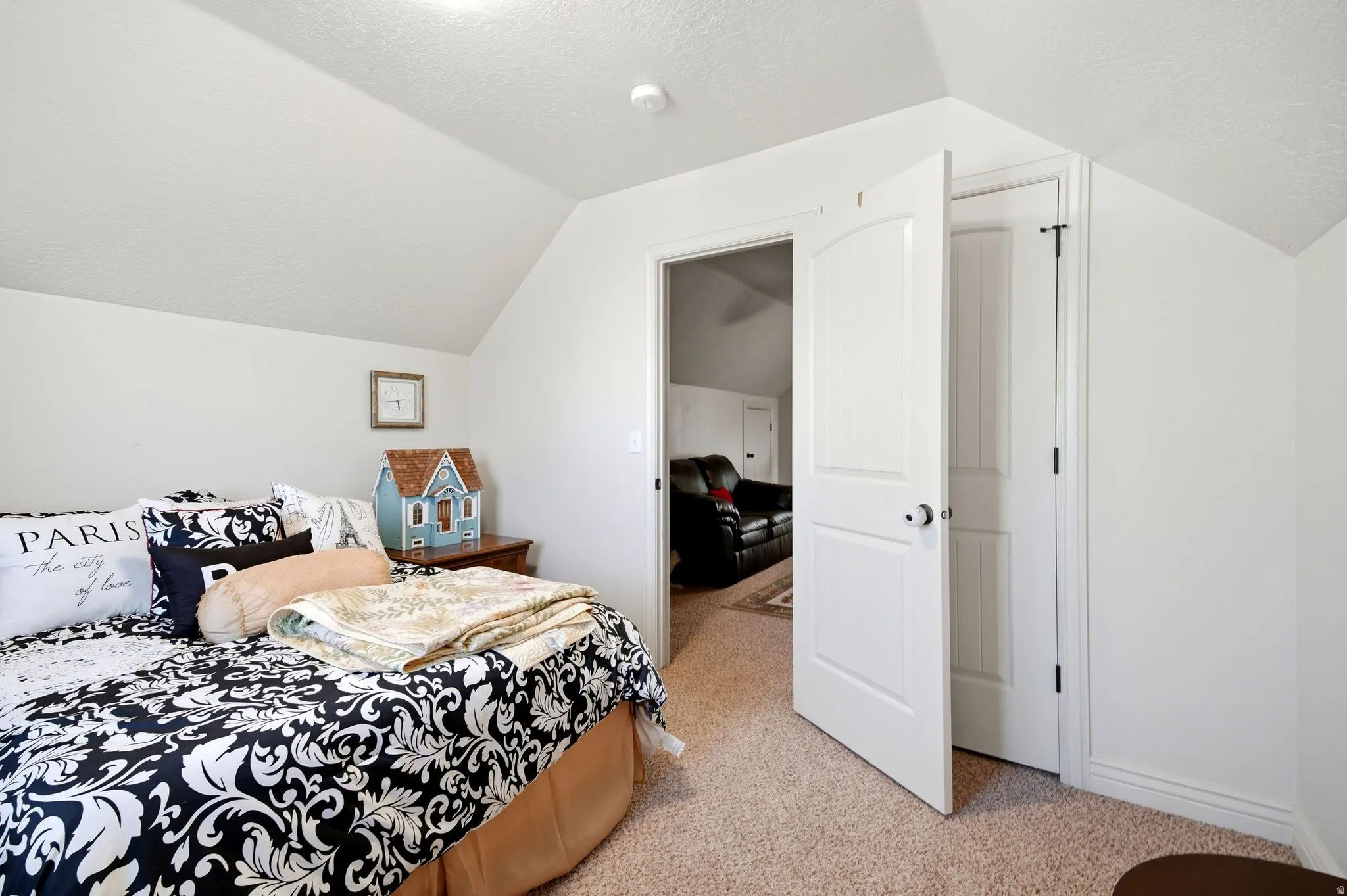 Angled ceilings, white paneled doors, and neutral carpet flooring
