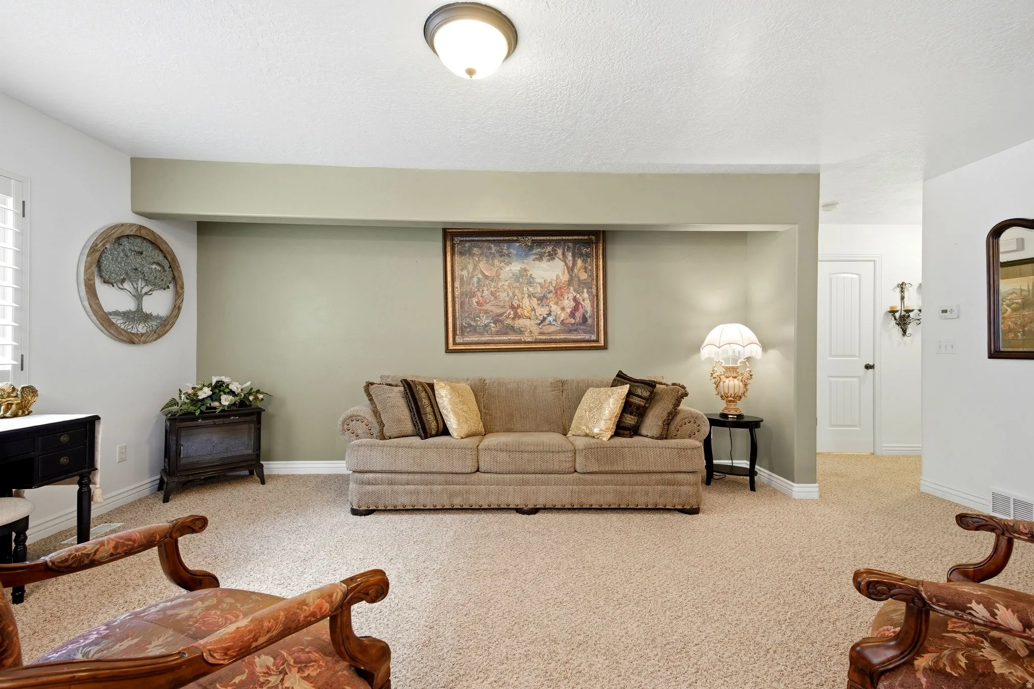 Recessed wall feature with accent paint, light-toned carpet, white painted trim, and a ceiling-mounted light fixture