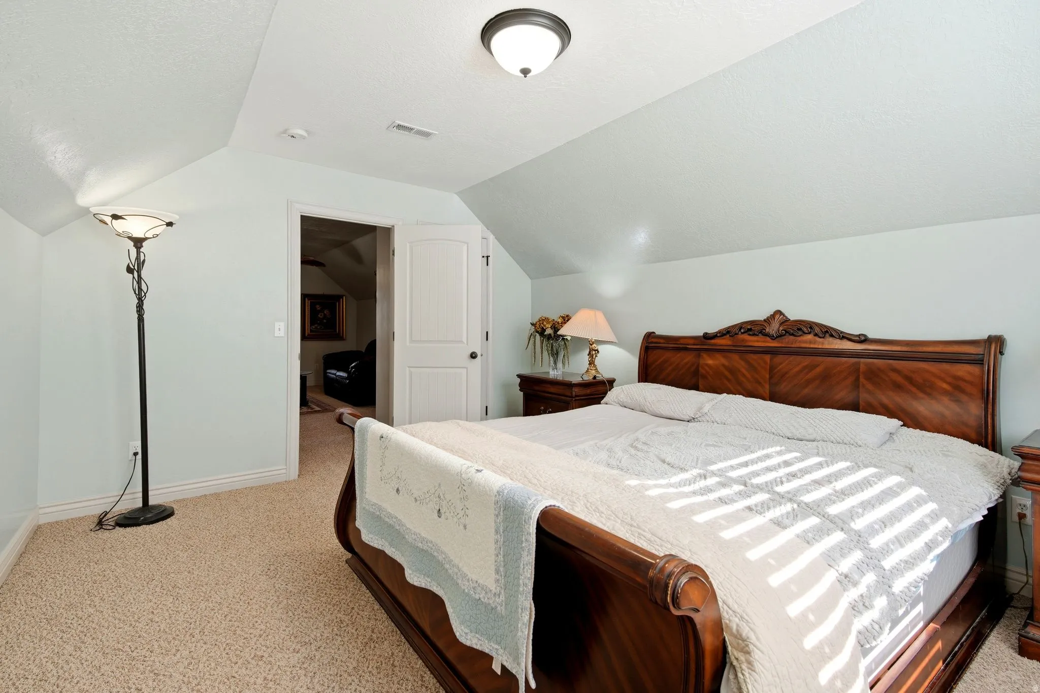 Carpeted flooring with sloped ceilings and a solid core door