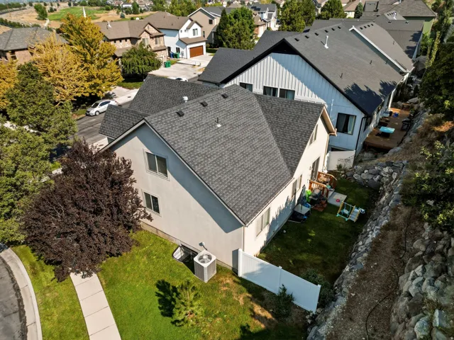Two-story property with a gray shingle roof and stucco siding