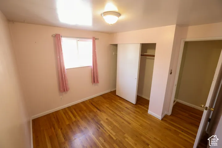 Hardwood flooring, recessed window, built-in closet with sliding doors, flush mount ceiling light fixture