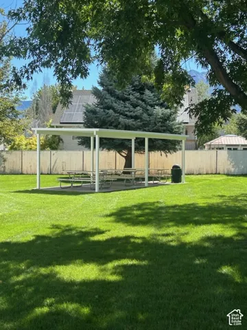 HOA community park expansive green space featuring a covered outdoor structure and mature trees