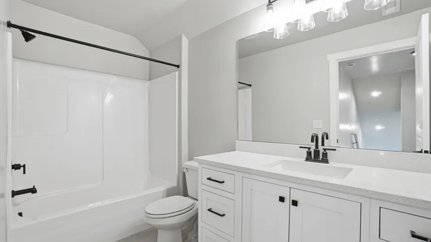 Bathroom featuring a white vanity with a light-toned countertop, an integrated sink, and black hardware