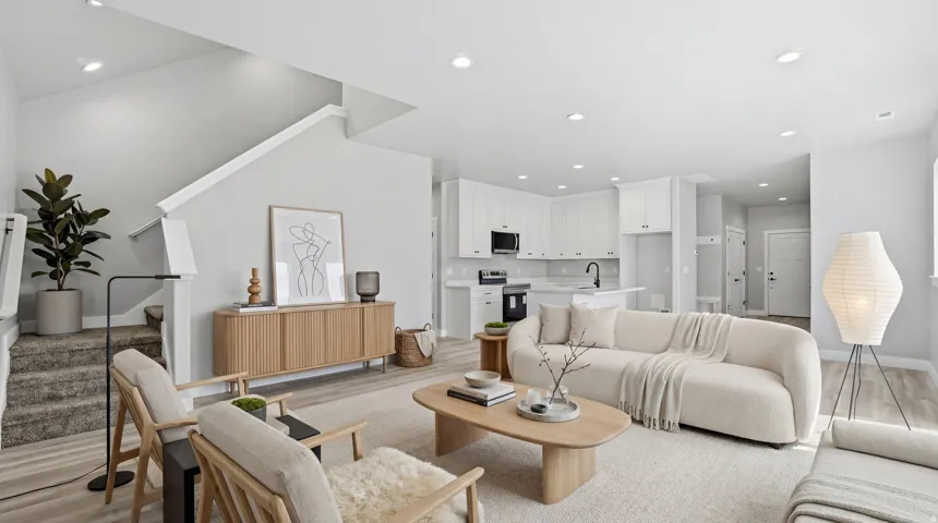 Open-concept living space featuring recessed lighting, light wood-finish flooring, and a staircase with carpeted treads