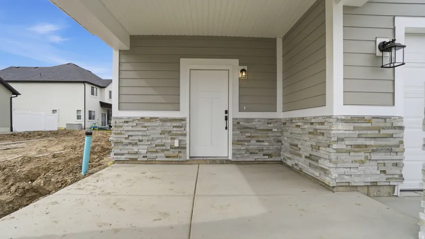 Covered front entry with stone veneer accent siding and horizontal siding