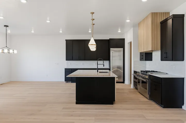 Open concept space featuring wood-finish flooring, recessed lighting, and a kitchen with dark cabinetry