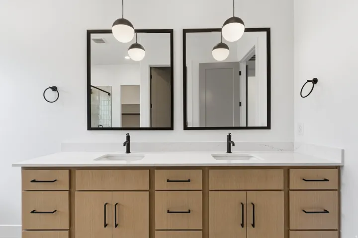 Double vanity with light wood-finish cabinetry, white countertop, and dual rectangular undermount sinks