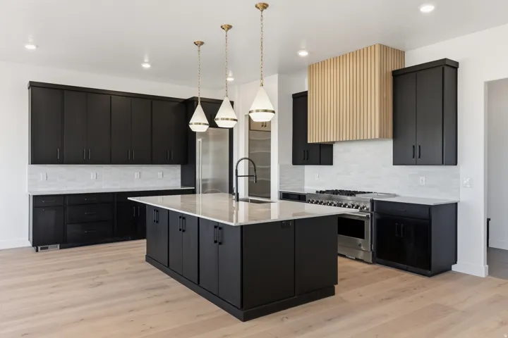 Kitchen featuring dark wood-finish cabinetry, light wood-finish flooring, a central island with a light-colored countertop, stainless steel appliances, and a wood-slat range hood