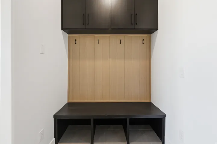 Built-in storage bench with three cubbies and a wood-panel back