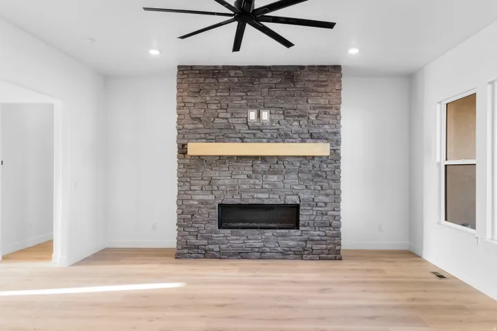 Stone-clad fireplace with wood-finish mantel and electric insert