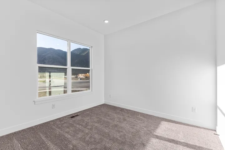 Recessed lighting, neutral wall tones, large window, mountain scenery, and plush carpeting