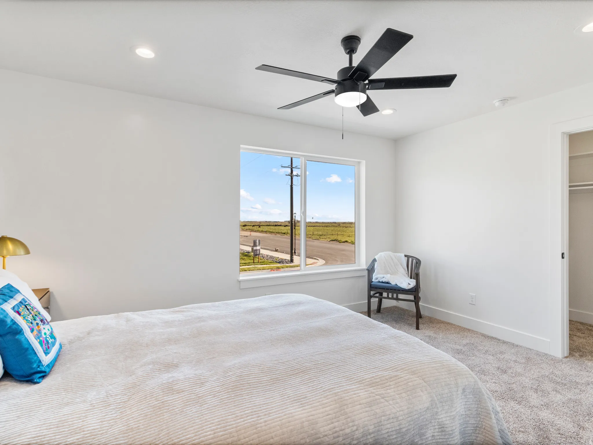 Recessed lighting, ceiling fan with integrated light, carpeted flooring, and a single window with white trim