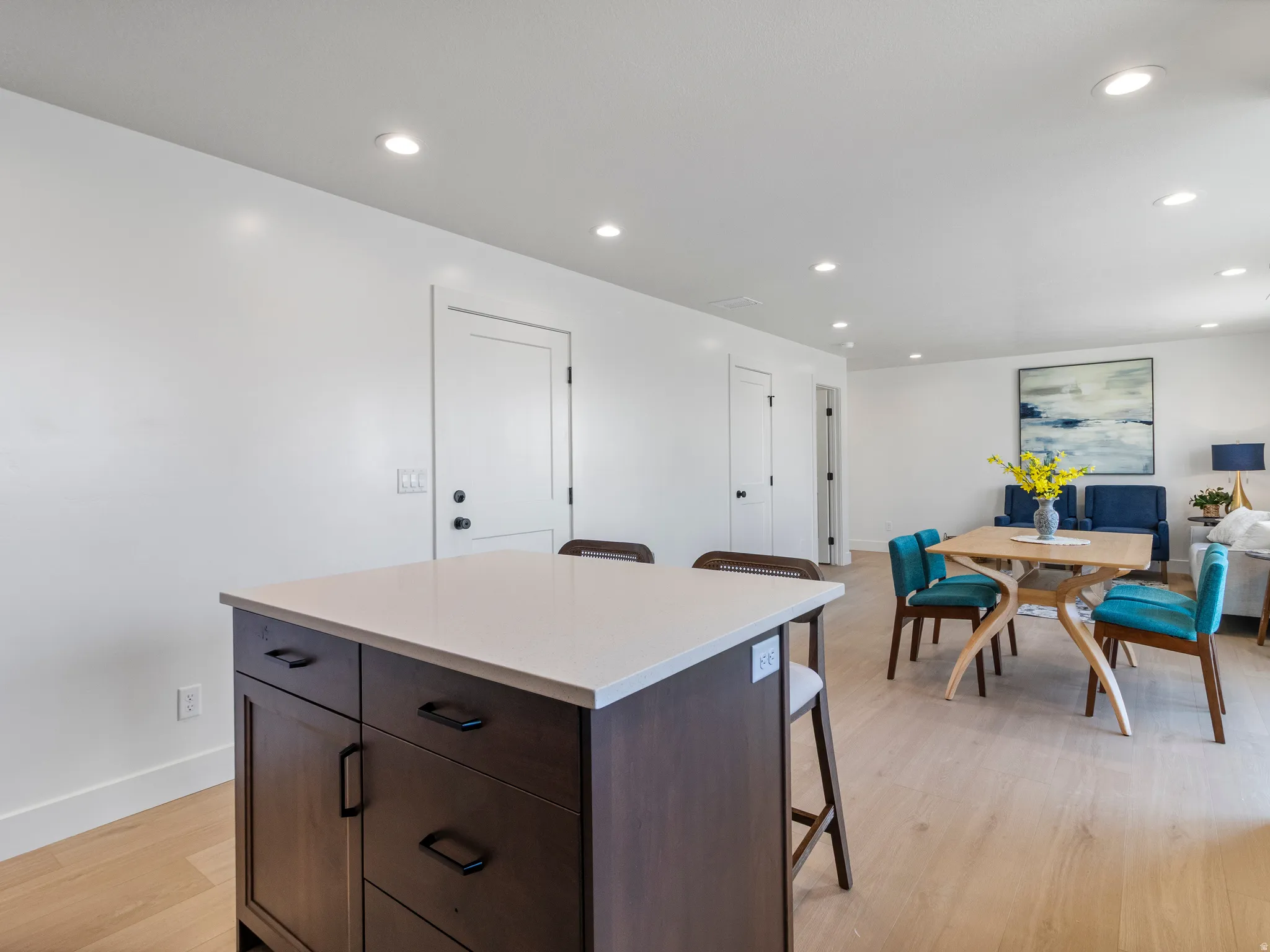 Central kitchen island with wood-finish cabinetry and light-toned countertop