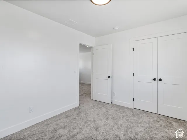 Plush gray carpeting, white painted walls, and white interior doors with black hardware