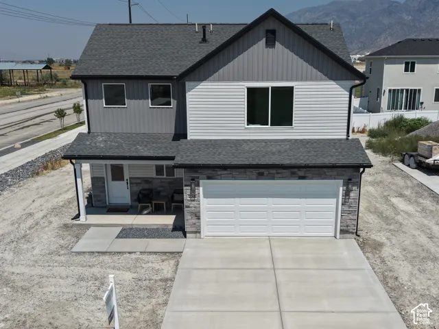 Two-story residence featuring a covered entry, attached two-car garage, and concrete driveway
