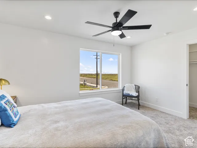Recessed lighting, ceiling fan with integrated light, carpeted flooring, and a single window with white trim