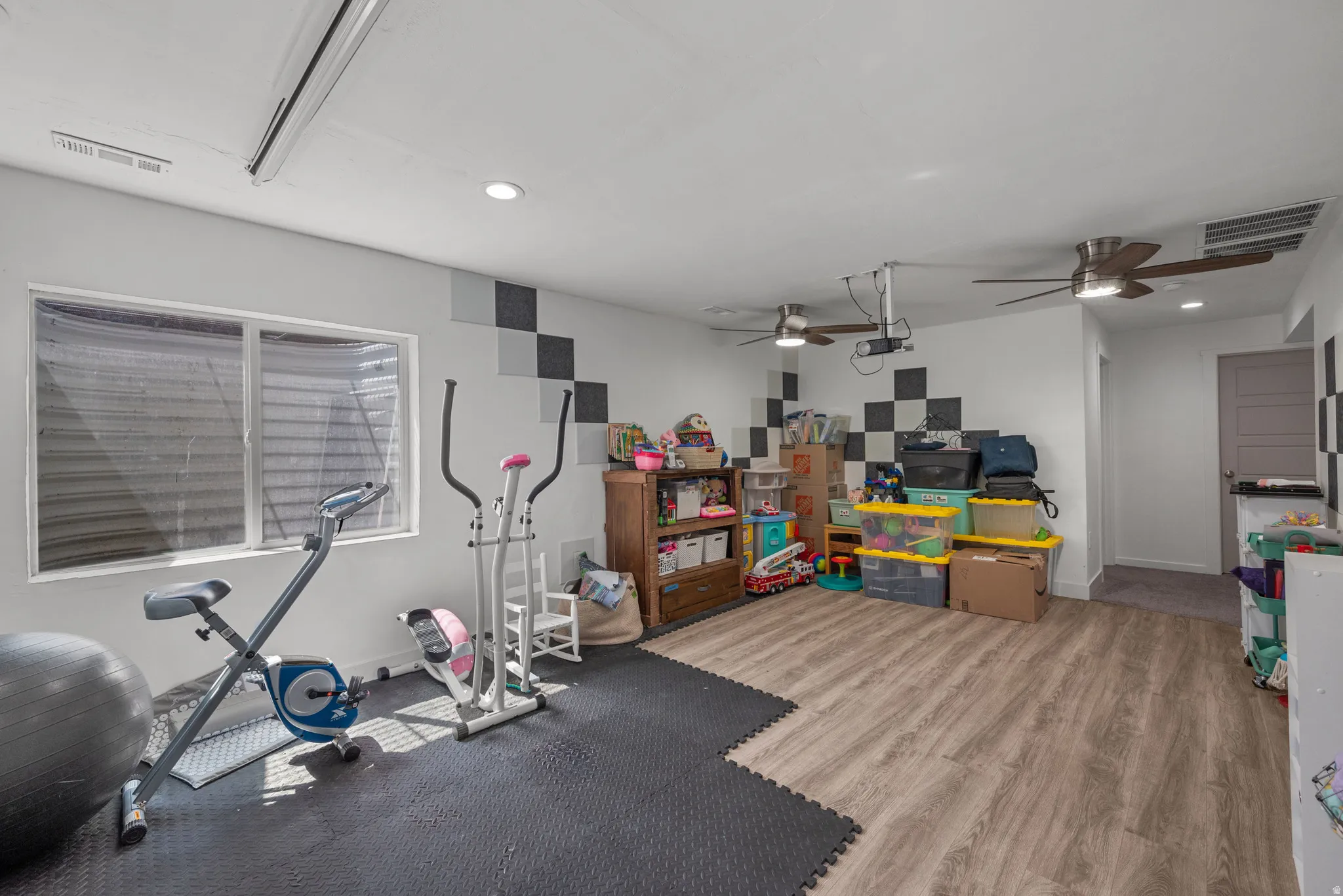 Recessed lighting, two ceiling fans, wood-finish flooring, and a built-in window