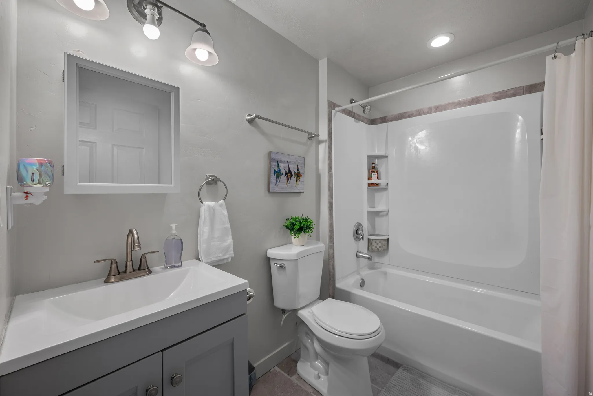 Modern bathroom featuring a single vanity with a white countertop and gray cabinetry