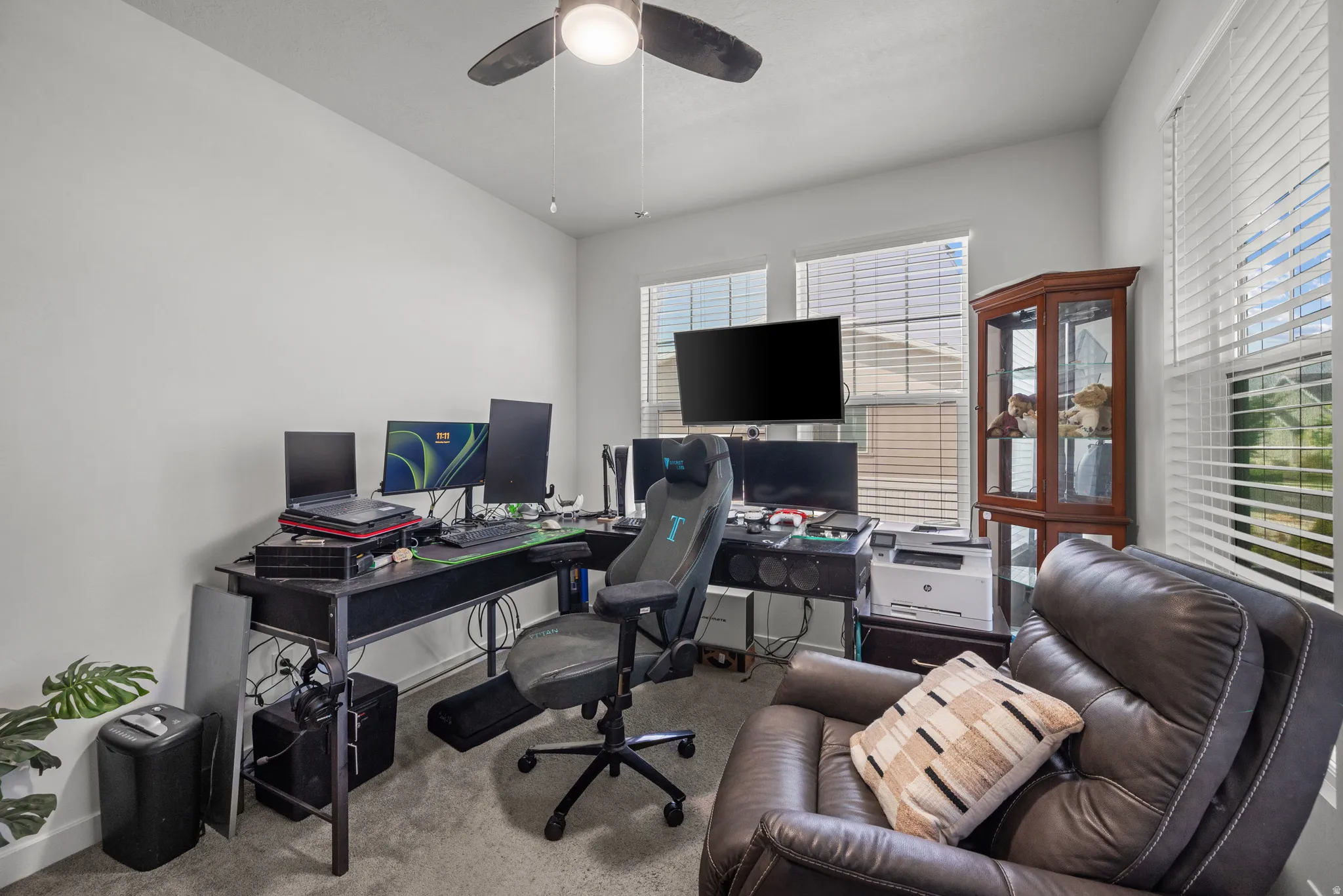Ceiling fan, multiple windows with blinds, and neutral wall paint
