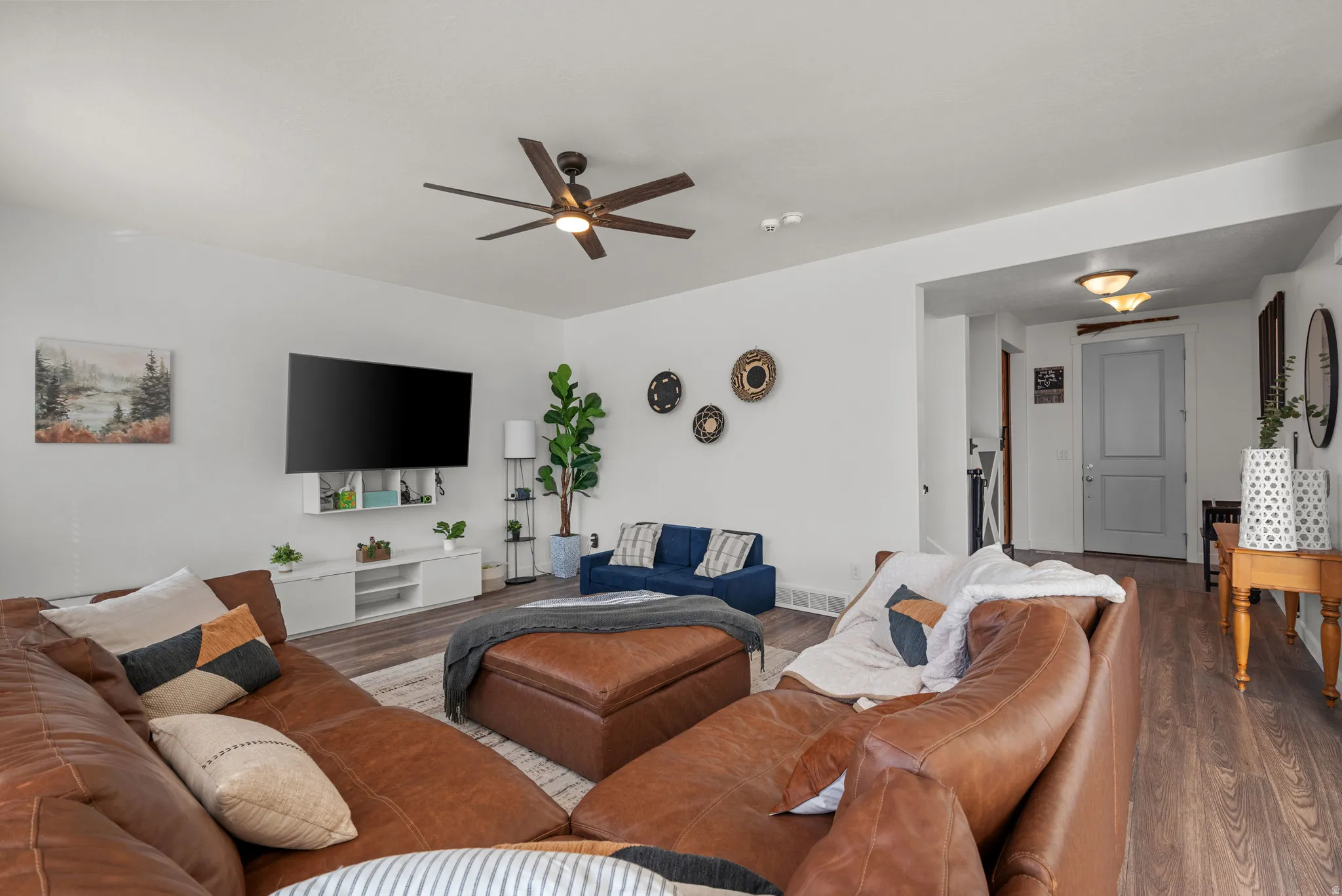Spacious living area featuring wood-finish flooring, a ceiling fan, and recessed lighting