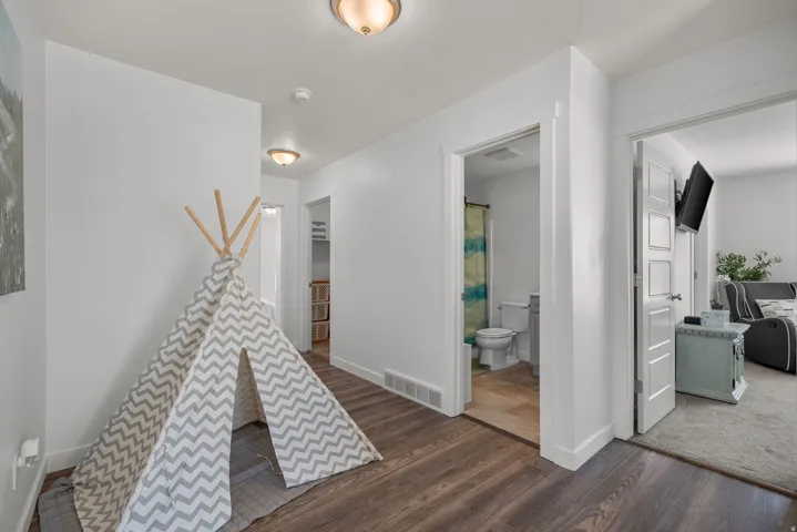 Wood-finish flooring, white walls, and recessed lighting